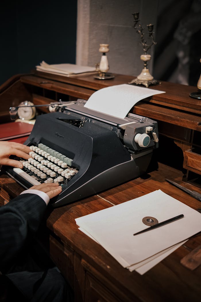 Old-fashioned typewriter on desk with papers, ideal for vintage business concepts.